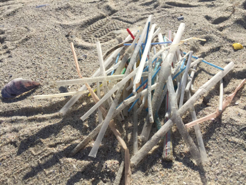 Plastikstrohhalm im Sand Plastikstrohhalm